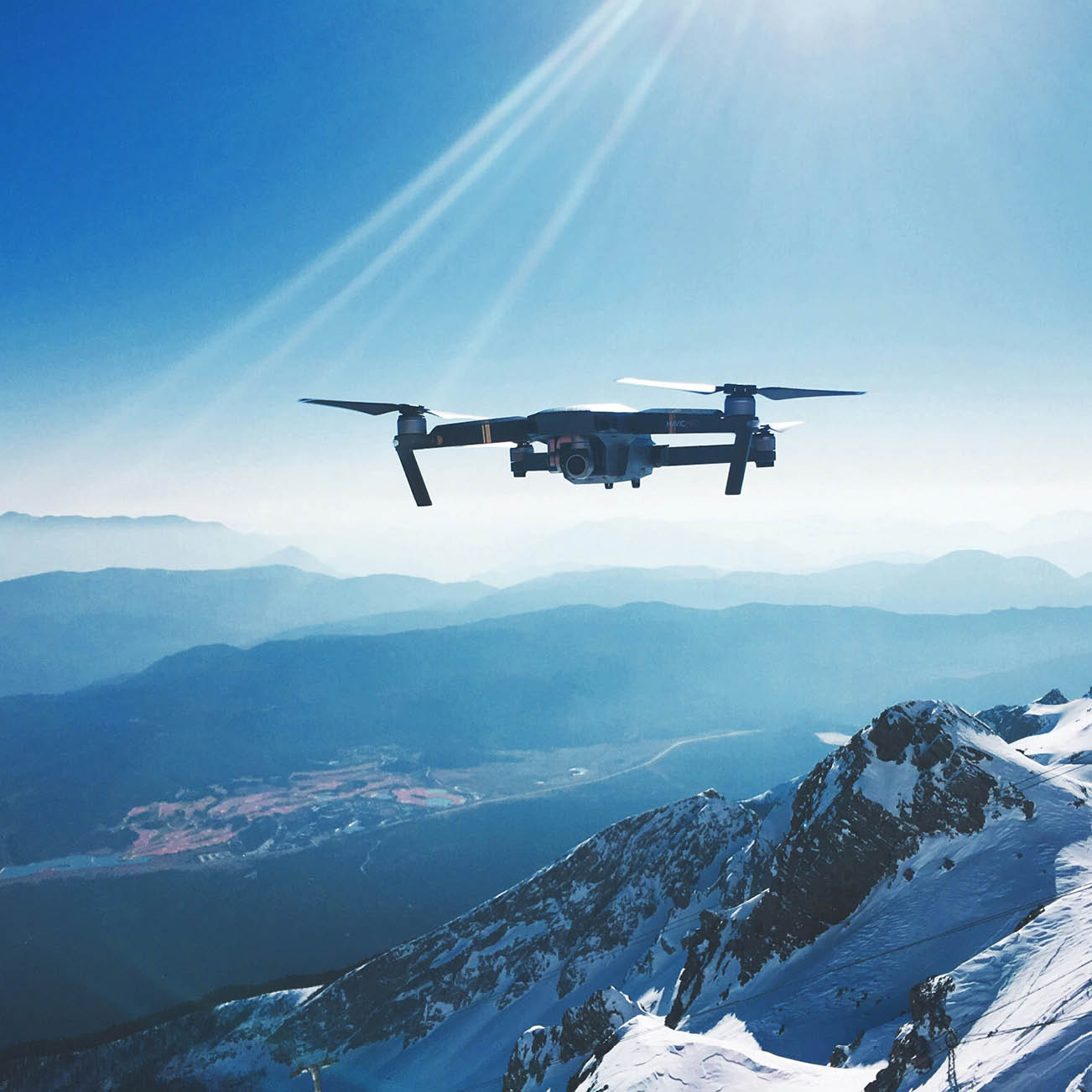 drone flying over mountains in the sunlight