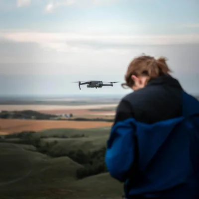 female drone pilot remote operating a drone