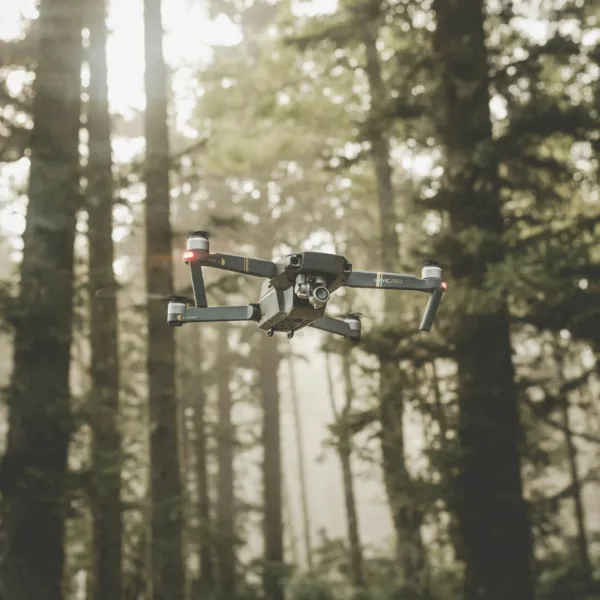 drone flying amidst backdrop of trees in a forest